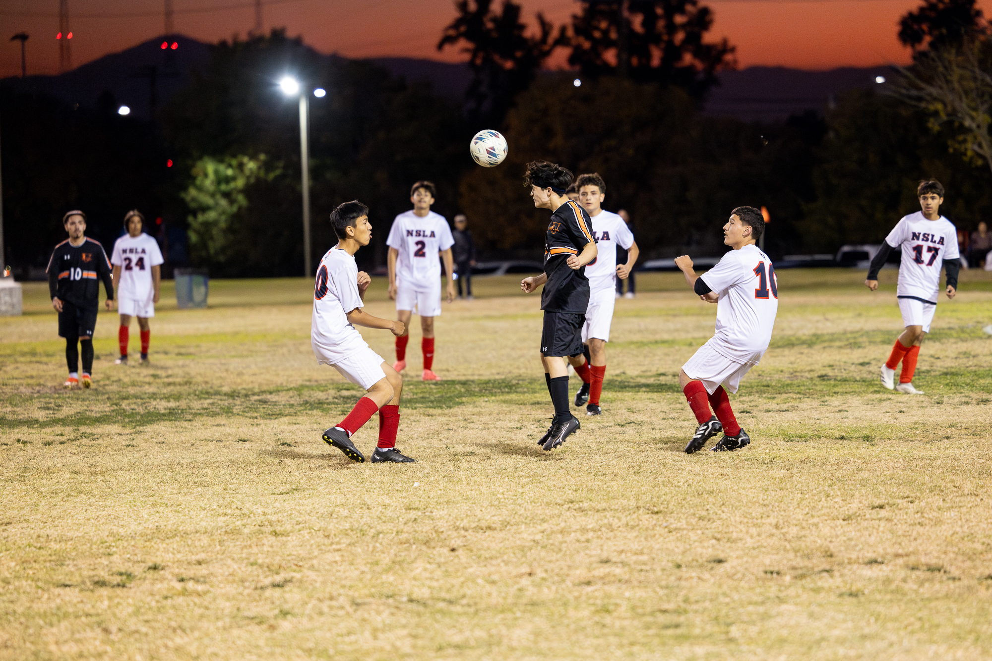 Sophomore Angel Alvarez ('27) (front left) and senior Edward Munoz ('25) (front right) look to intercept Entrepreneur's head-butt. (Photo credit: Ellis Evans)