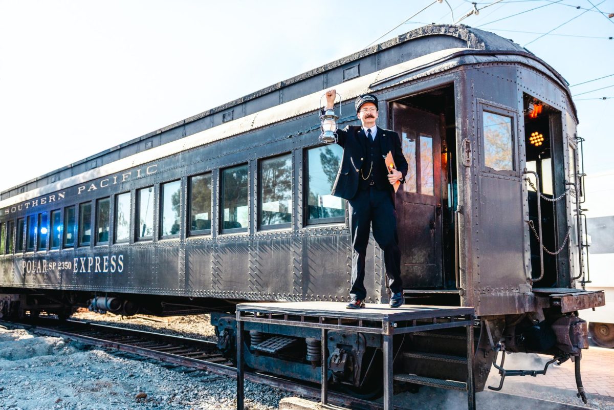 The Polar Express conductor holds his lantern up, ready to call passengers aboard, at the Southern California Railway Museum in Perris, California, on Sunday, Dec. 16, 2024. (Photo credit: David Ruiz)