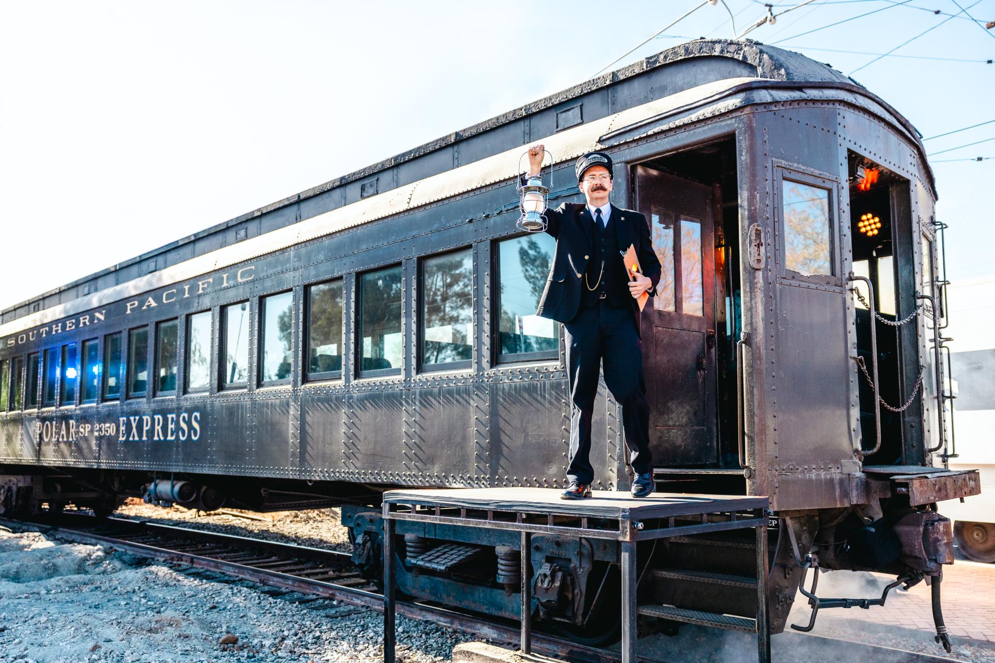 The Polar Express conductor holds his lantern up, ready to call passengers aboard, at the Southern California Railway Museum in Perris, California, on Sunday, Dec. 16, 2024. (Photo credit: David Ruiz)