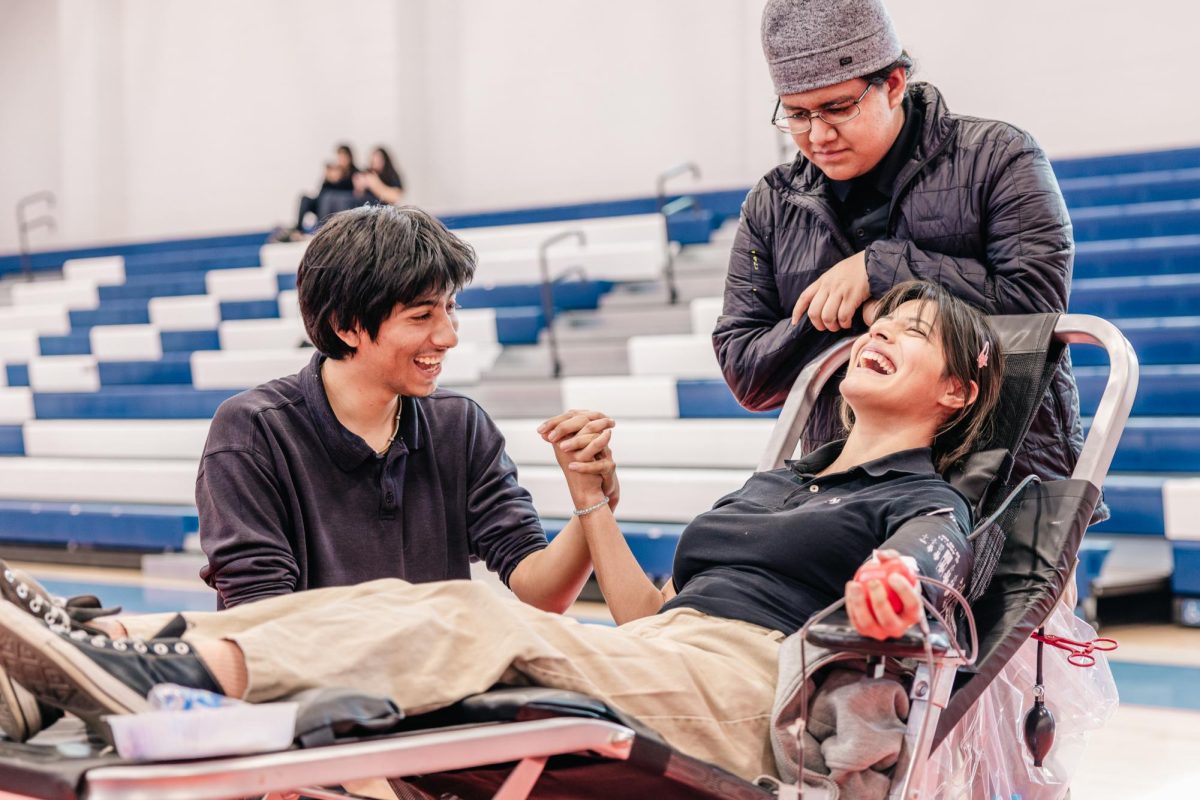 Teremildred Estrada ('25) (center) laughs as Johnny Rivera ('25) (left) and Norton ambassador David Ruiz ('26) (right) support her in donating blood on Jan. 22, 2025. (Photo credit: <a href=