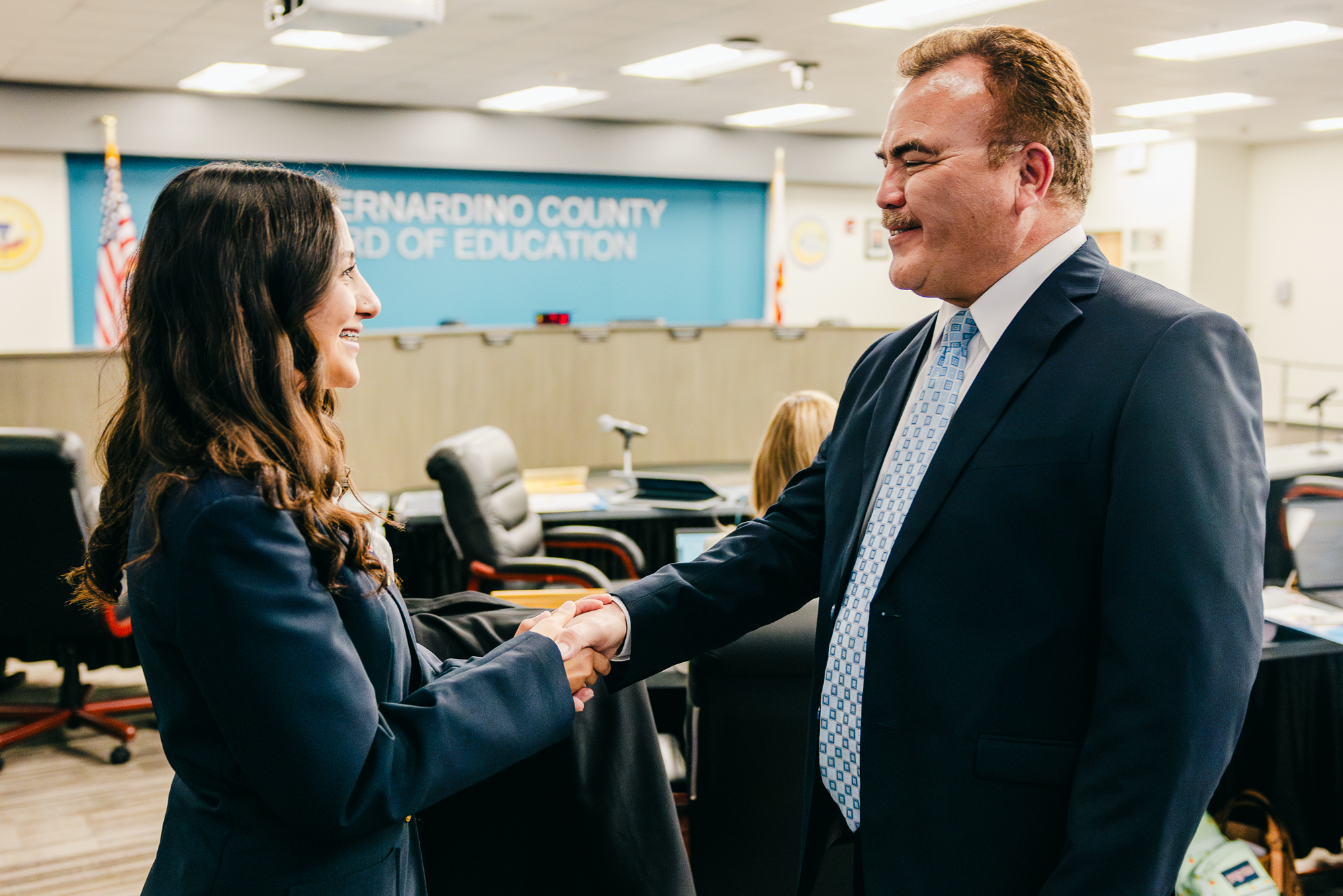 Norton ambassador Desiree Gago ('25) (left) shakes hands with San Bernardino County Superintendent Ted Alejandre (right) before the San Bernardino County Board of Education met to vote on Norton's charter renewal on Monday, Mar. 10, 2025. (Photo credit: Ellis Evans)