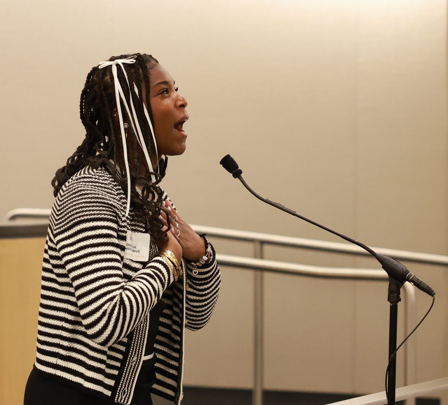 Toochi Samsylvanus ('27) delivers her final poem, "a song in the front yard" by Gwendolyn Brooks at the 2025 California Poetry Out Loud Finals on Mar. 17, 2025. Samsylvanus' ('27) recitation marks the end of the second day's final round held at the State Capitol Annex Swing Space. Each student reciter was required to recite three poems that met the requirements from Poetry Out Loud . The requirements for the three poems are: 1) one poem must be 25 lines or fewer, 2) one poem must be written before the 20th century, and 3) one poem may be used to meet the first two criteria and be the student's final poem. Samsylvanus' ('27) three poems were: 1) "Shall earth no more inspire thee" by Emily Brontë, 2) "No Coward Soul is Mine" by Emily Brontë, and 3) "a song in the front yard" by Gwendolyn Brooks. (Photo courtesy of David Tellyer.)