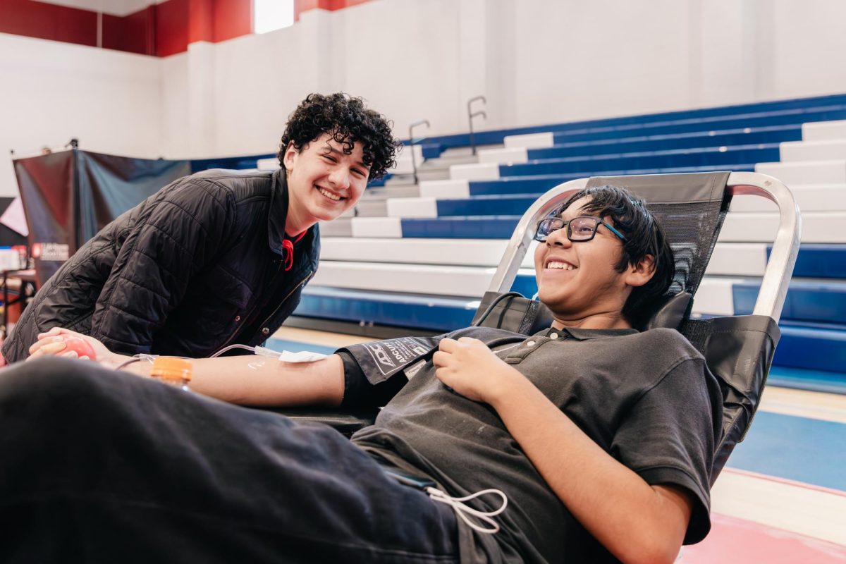 On Wednesday, Oct. 22, 2025, Norton ambassador Leobardo Morales ('27) smiles with sophomore Shayn Gutierrez ('28) as he donates blood at Norton's first blood drive of the 2025-26 school year. The drive marks the start of Norton's second year running blood drives facilitated by student ambassadors and hosted by LifeStream blood bank, a local non-profit. (Photo credit: Ellis Evans)